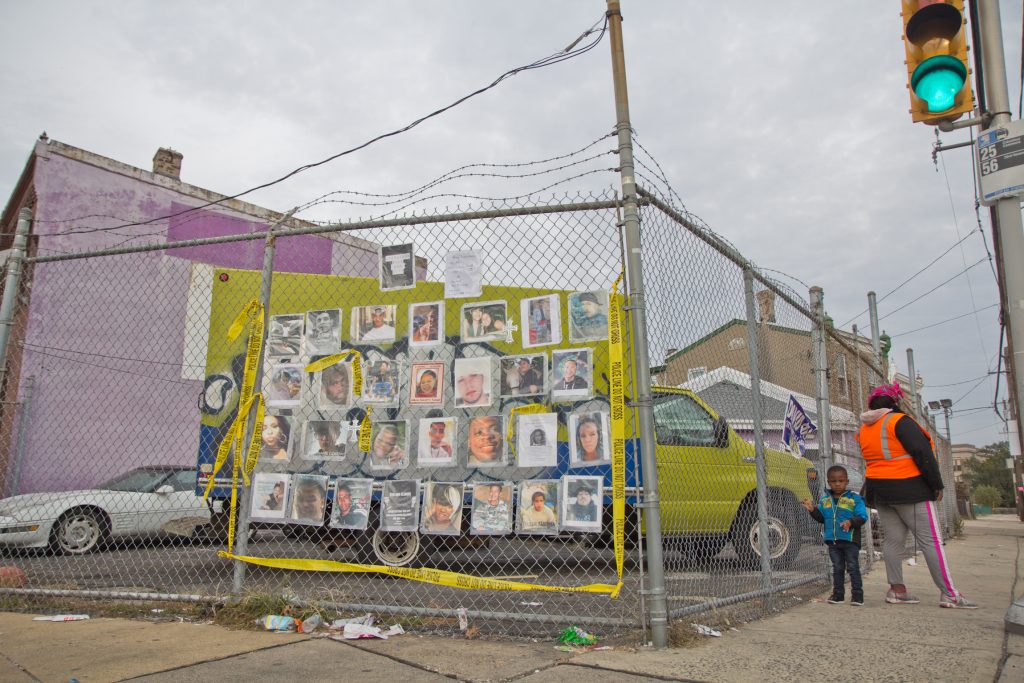 2019 11 7 k paynter 10 year-old shot-3 Ros Pichardo, an activist with Operation Save Our City, hung the photos of other victims of gun violence across from the spot where 10 year-old Semaj O’Branty was shot in the head walking home from school Wednesday. (Kimberly Paynter/WHYY)