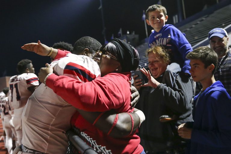 Stony Brook defensive lineman Casey Williams hugs his mother, Zina Williams, while surrounded by friends and family after his team defeated Villanova on Saturday, Oct. 26, 2019. (Heather Khalifa/The Philadelphia Inquirer)