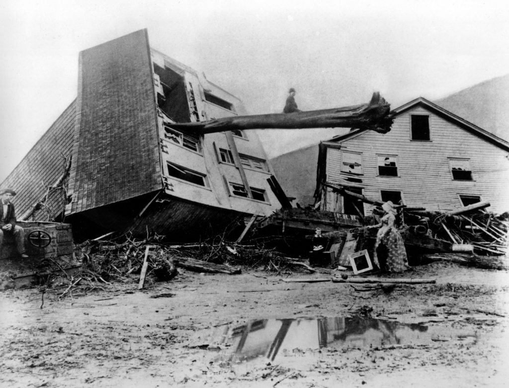 AP_100752221142-1920×1464 In this historical photo from May 31, 1889, survivors stand by homes destroyed when the South Fork Dam collapsed in Johnstown, Pa. As officials prepare to commemorate the 125th anniversary of the enormous Johnstown Flood of 1889 that killed 2,209 people, new research has helped explain why the deluge was so deadly. (AP Photo)