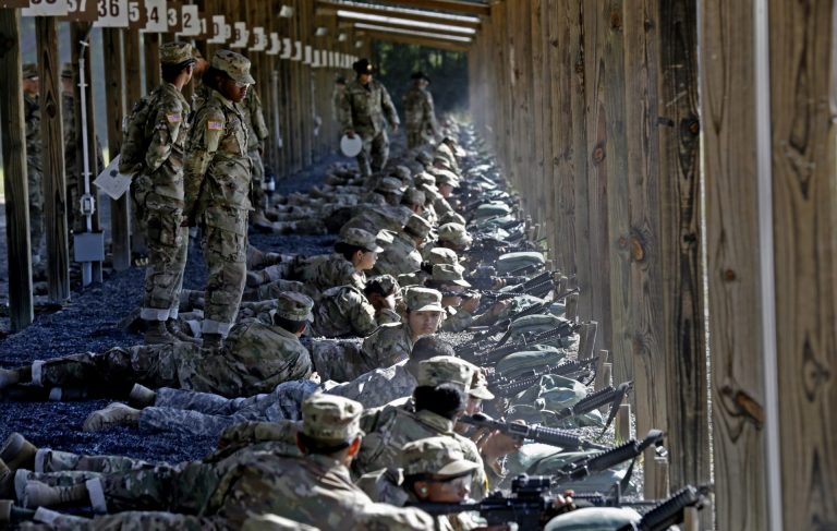 FILE - In this Aug. 17, 2016, file photo, Army drill sergeants stand over recruits during a live-fire marksmanship training course at Fort Jackson, S.C. Under the gun to increase the size of the force, the Army is pouring an extra $200 million into bonuses this year to attract and retain soldiers, and has approved more drug use and conduct waivers for recruits in order to build the ranks. (Gerry Broome/AP Photo)