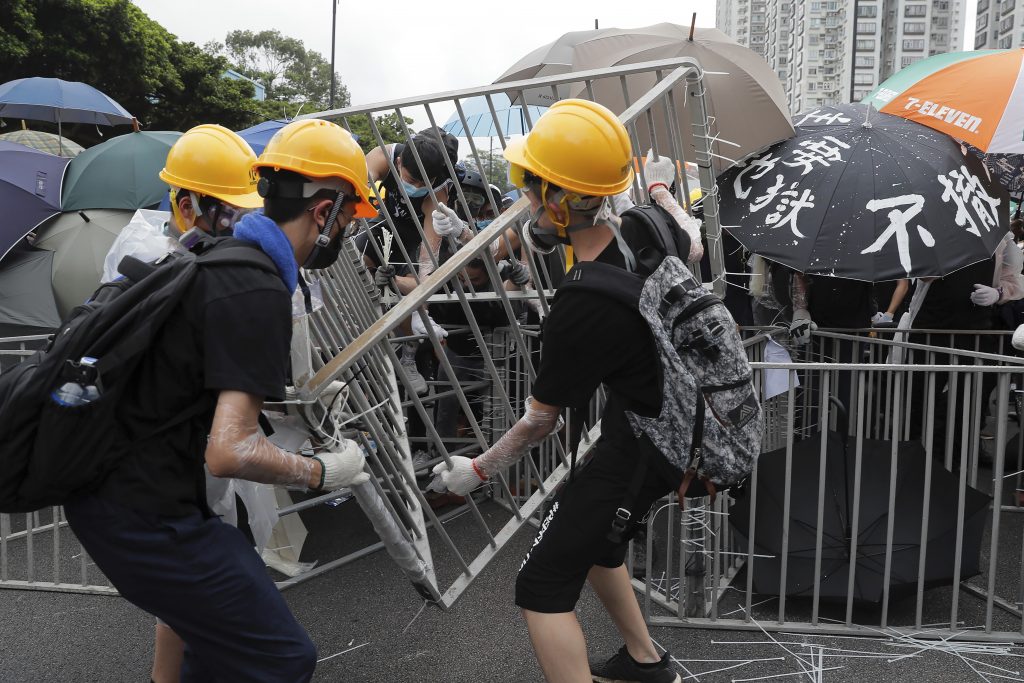 Hong Kong Protests Protesters with umbrellas use steel barricades to block a road as they march through Sha Tin District in Hong Kong. (Kin Cheung/AP Photo)