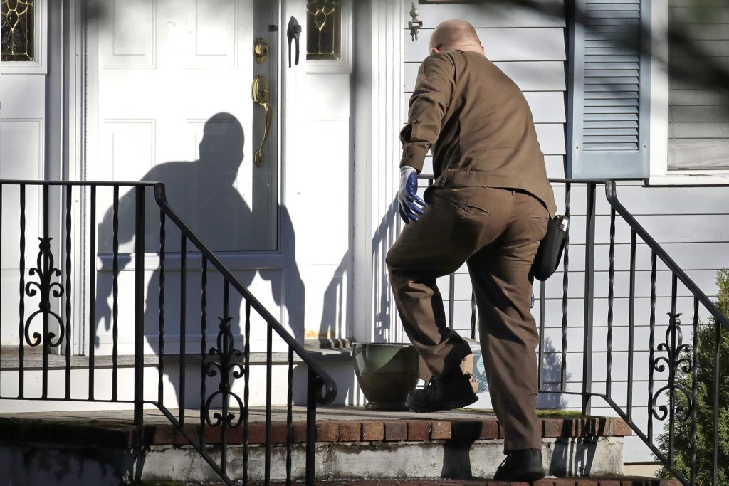 Holiday One Day Delivery In this Nov. 26, 2019, file photo a UPS man delivers an Amazon package to a residence in North Andover, Mass. Amazon, Walmart and others are promising to deliver more of their goods in a day and this holiday season will be the first real test of whether they can make that happen. (Elise Amendola/AP Photo)