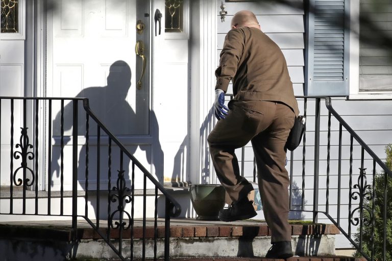 In this Nov. 26, 2019, file photo a UPS man delivers an Amazon package to a residence in North Andover, Mass. Amazon, Walmart and others are promising to deliver more of their goods in a day and this holiday season will be the first real test of whether they can make that happen. (Elise Amendola/AP Photo)
