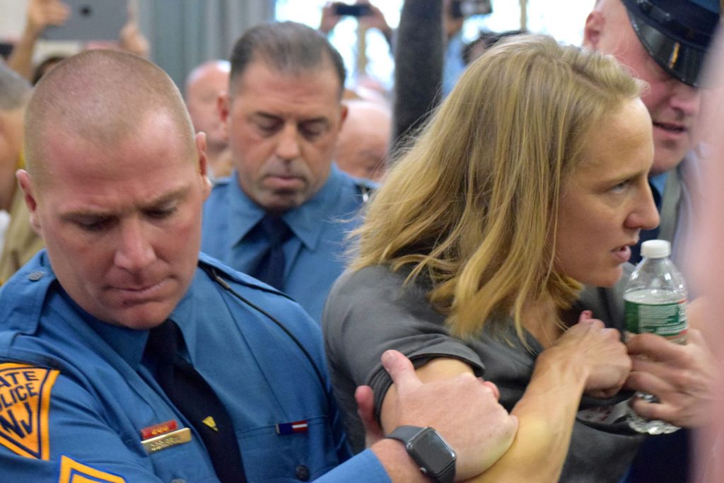 DSC_0133 State police remove Sue Altman of New Jersey Working Families from a hearing. (NJ Spotlight)