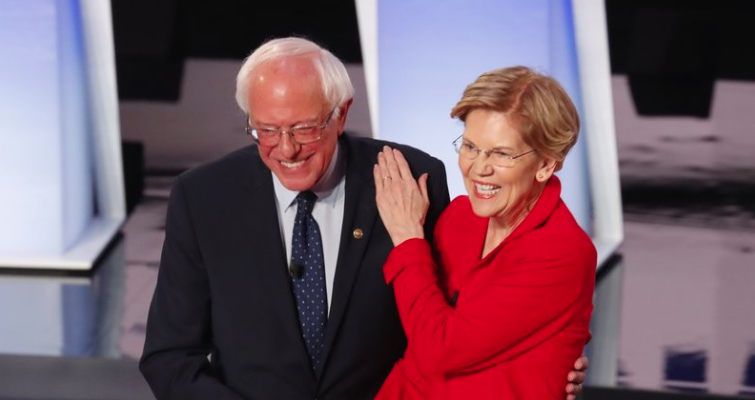 Screen Shot 2019-11-25 at 2.03.35 PM Sen. Bernie Sanders, I-Vt., and Sen. Elizabeth Warren, D-Mass., are proposing to forgive student debt for most Americans. They greet each other at a Democratic primary debate in July. (Paul Sancya/AP Photo)