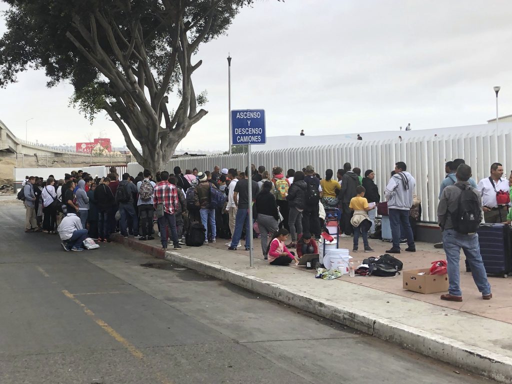 Asylum seekers in Tijuana, Mexico, listen to names being called from a waiting list to claim asylum at a border crossing in San Diego on Sept. 26. Asylum seekers in Tijuana, Mexico, listen to names being called from a waiting list to claim asylum at a border crossing in San Diego on Sept. 26. (Elliot Spagat/AP Photos)
