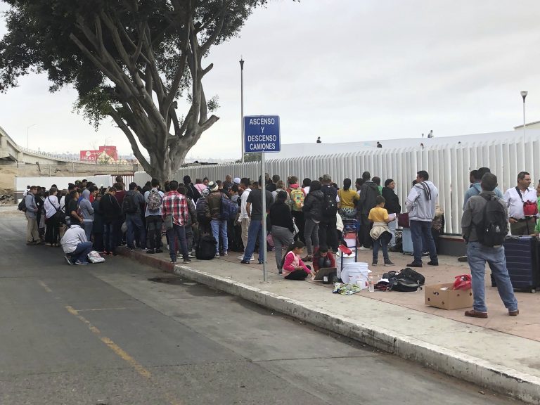 Asylum seekers in Tijuana, Mexico, listen to names being called from a waiting list to claim asylum at a border crossing in San Diego on Sept. 26. (Elliot Spagat/AP Photos)