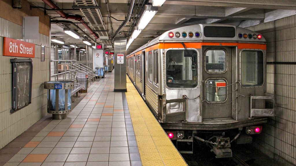 A subway car sits at a platform at the 8th Street station