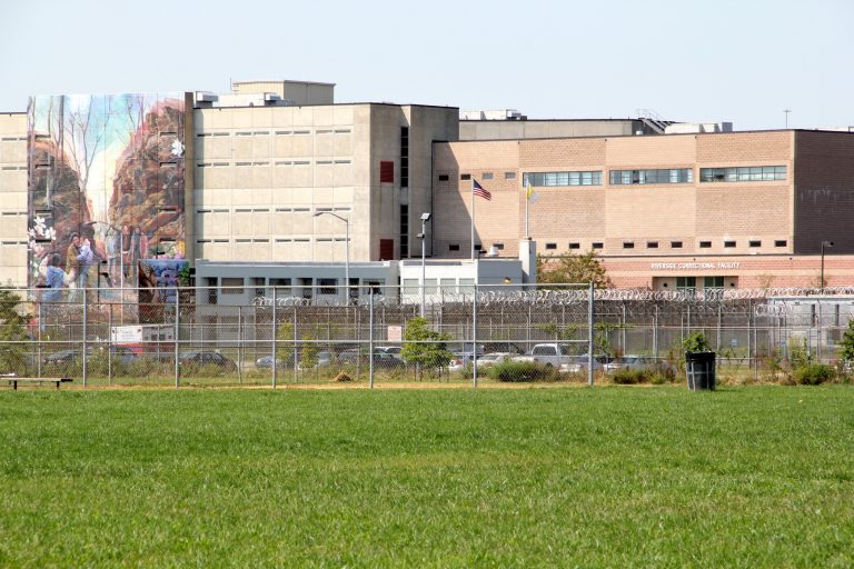 An exterior of a prison is shown, with green grass visible in the foreground.