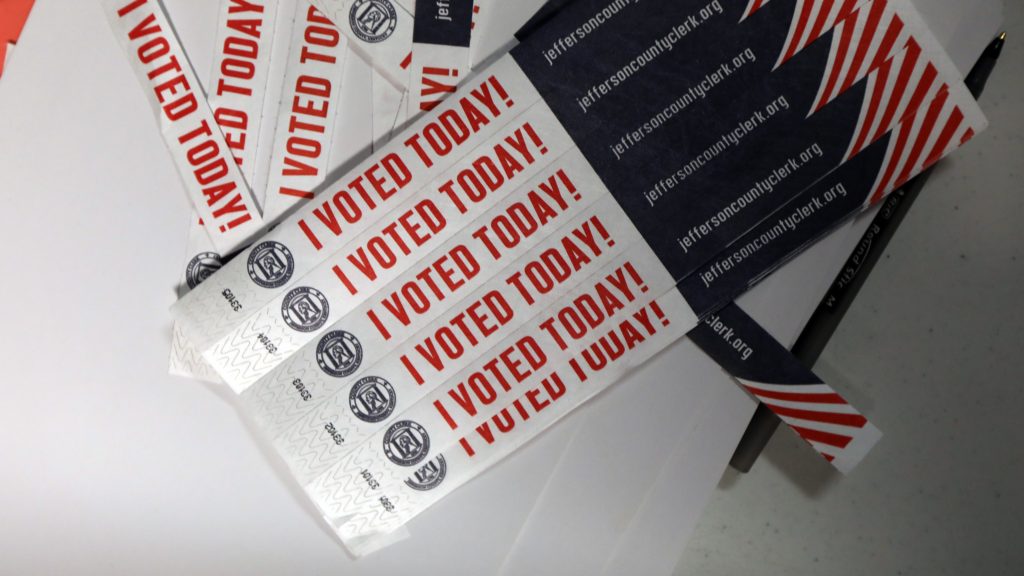 Despite unanswered questions about security and transparency, mobile voting pilots aimed at overseas and military voters move forward in a number of states. Above, wristbands noting “I Voted Today!” are available at Sojourn Community Church in Louisville, Ky., on Election Day this year. Despite unanswered questions about security and transparency, mobile voting pilots aimed at overseas and military voters move forward in a number of states. Above, wristbands noting