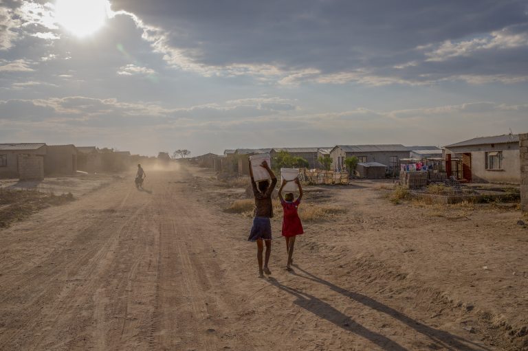 Girls carry containers of water filled from the local communal tap Zimbabwe, which is in the grip of a nationwide drought that has been linked to climate change. (Cynthia R. Matonhodze/Bloomberg/Getty Images)