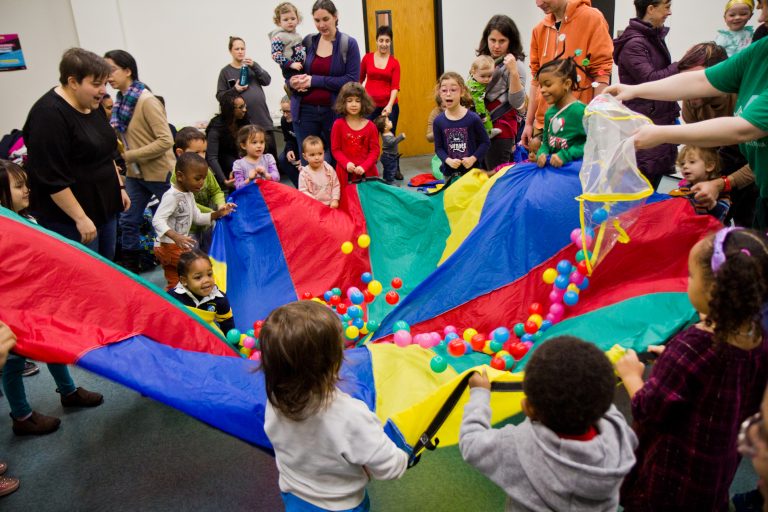 Kids at the Lucien E. Blackwell West Philadelphia Regional Library celebrate “Noon Year’s Eve” by playing with a parachute. (Kimberly Paynter/WHYY)