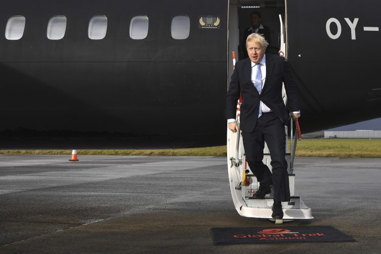 Britain's Prime Minister Boris Johnson arrives at Cardiff Airport while on the General Election campaign trail in Wales, Wednesday, Dec. 11, 2019. Britain goes to the polls on Dec. 12. (Ben Stansall/Pool Photo via AP)