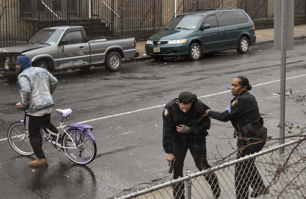 Jersey City Guns Jersey City police Sgt. Marjorie Jordan, right, helps fellow officer Raymond Sanchez to safety after he was shot during a gunfight that left multiple dead in Jersey City, N.J. (Justin Moreau/AP Photos)