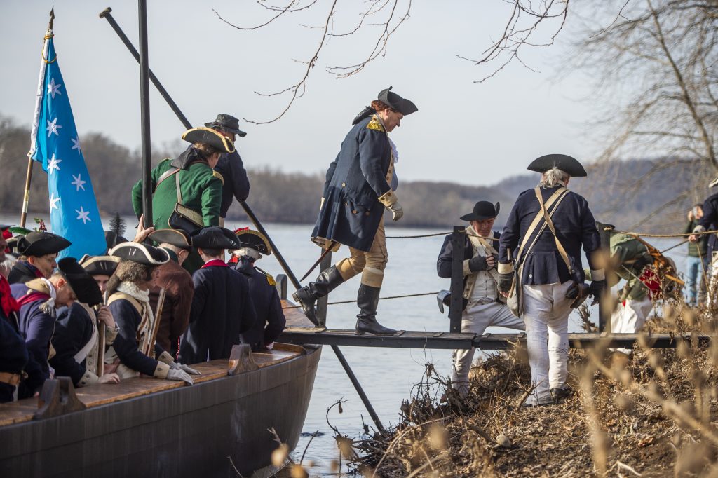 George Washington portrayed by John Godzieba steps ashore on the New Jersey side of the Delaware River. (Jonathan Wilson for WHYY)