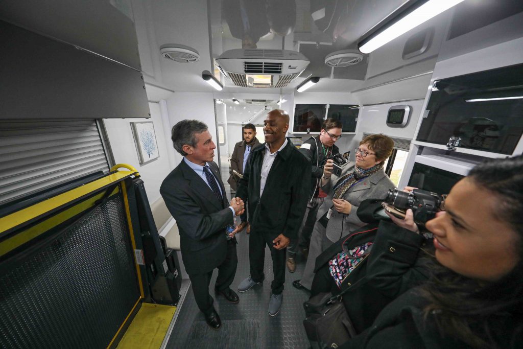 News 2020 – JAN 13 – State and local officials tour mobile bridge van at Howard R. Young Correctional Institution where inmates being released get re-entry services. Tyrone Mathis (right) and Del. Gov. John Carney (left) shake hands after touring