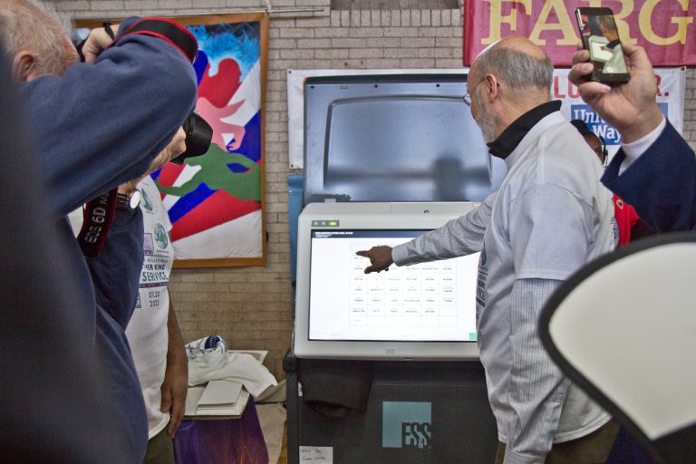 Pa. Gov. Tom Wolf poses with Pennsylvania’s new voting machines at the MLK Day of Service at Philadelphia’s Girard College. (Kimberly Paynter/WHYY)