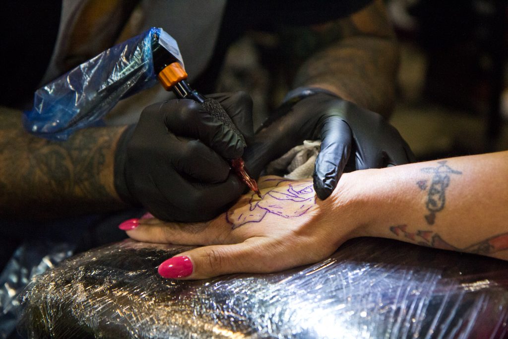 2020 1 17 k paynter tattoo 2020-12 Felicia Vazquez gets a rose tattooed onto her hand by artist Ralph Fryer. (Kimberly Paynter/WHYY)