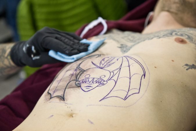 Micky Kahrs receives an “Impossible Kid” from artist Sal Ffiti. (Kimberly Paynter/WHYY)