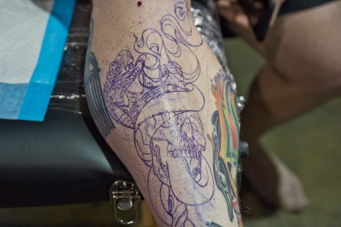 Art by Elisheba Israel Mrozik about to be tattooed on Gil Goodman. Both traveled from Nashville to the Philadelphia 2020 Tattoo Convention. (Kimberly Paynter/WHYY)
