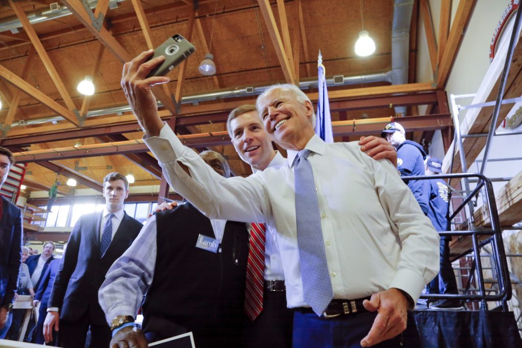 AP_18066023826940-1920×1281 Conor Lamb, center, then a Democratic candidate for the March 13 special election in Pennsylvania's 18th Congressional District, and former Vice President Joe Biden, right, pose for a selfie with a supporter during a rally at the Carpenter's Training Center in Collier, Pa., Tuesday, March 6, 2018. (Gene J. Puskar / AP Photo)
