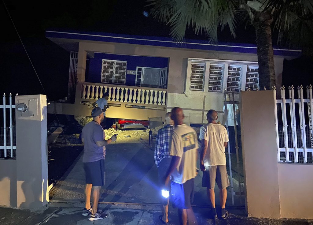 A collapsed building with car crushed underneath, following an earthquake in Yauco, Puerto Rico, Tuesday Jan. 7, 2020.  All the occupants of the home are reported to be uninjured.  A 6.5-magnitude earthquake struck Puerto Rico, the largest in a series of quakes in recent days, and caused heavy damage in some areas.  (J. Miguel Santiago Twitter via AP)