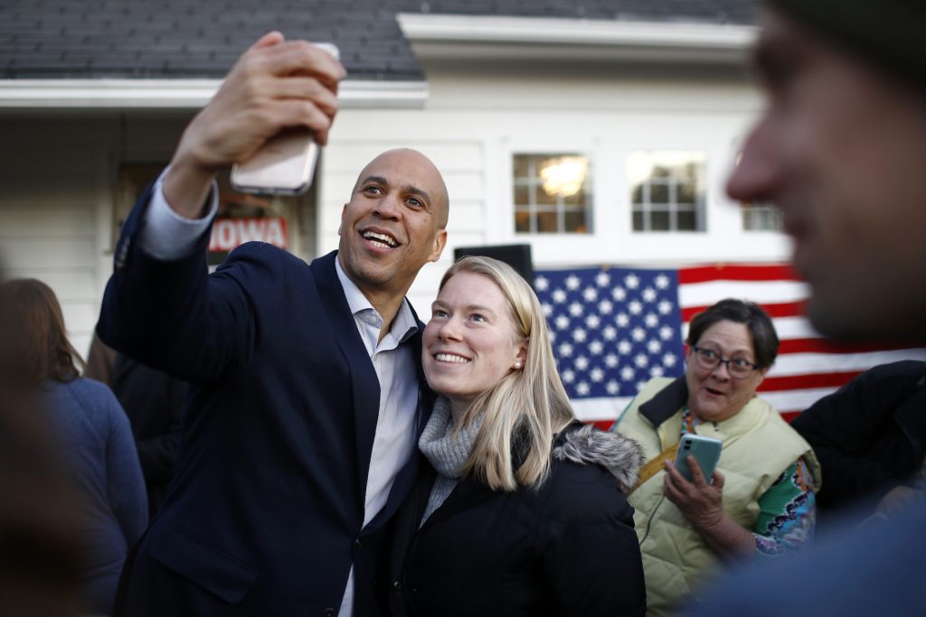 Cory Booker Democratic presidential candidate Sen. Cory Booker, D-N.J., poses for a selfie with an attendee after speaking at a campaign event at the home of Polk County Democratic Chair Sean Bagniewski, Tuesday, Jan. 7, 2020, in Des Moines, Iowa. (Patrick Semansky/AP Photo)