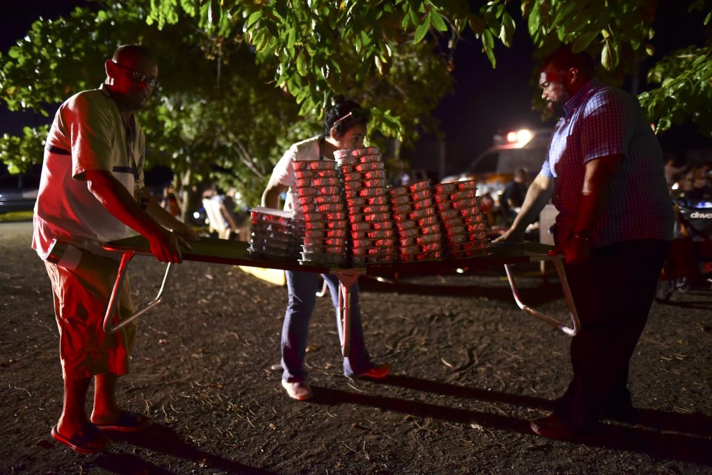 Puerto Rico Earthquake Volunteers move food for many refugees from Guanica that choose to remain outdoors for fear of possible aftershocks on their first night after a 6.4-magnitude earthquake struck Puerto Rico, killing one man, injuring at least eight other people and collapsing buildings, in Guanica, Puerto Rico, Tuesday, Jan. 7, 2020. (Carlos Giusti/AP Photo)