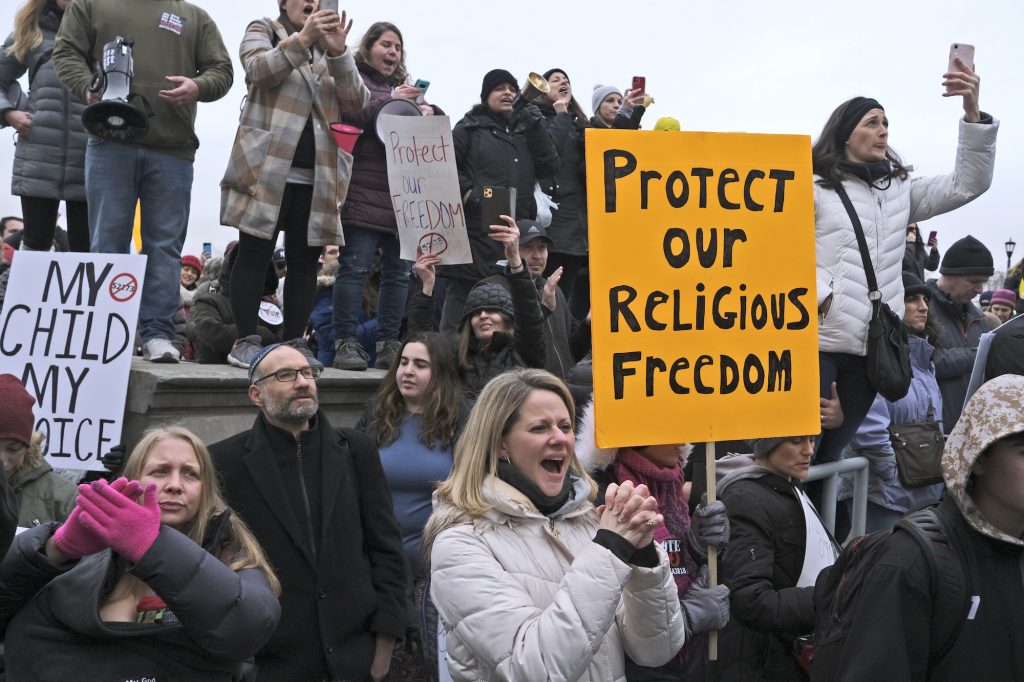 Vaccines Exemptions New Jersey People hold signs during a protest at the state house in Trenton, N.J., Monday, Jan. 13, 2020. New Jersey lawmakers are set to vote Monday on legislation to eliminate most religious exemptions for vaccines for schoolchildren, as opponents crowd the statehouse grounds with flags and banners. (Seth Wenig/AP Photo)
