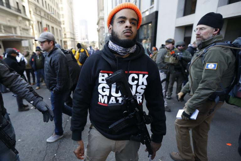A man walks in the crowd during a pro-gun rally, Monday, Jan. 20, 2020, in Richmond, Va. (Julio Cortez/AP Photo)