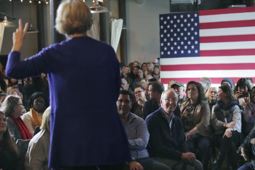 Elizabeth Warren, Bruce Mann In this Jan. 10, 2020, file photo, Bruce Mann, husband of Democratic presidential candidate Sen. Elizabeth Warren, D-Mass., right, smiles as he listens to his wife during a campaign stop in Dover, N.H. (Charles Krupa/AP Photo)