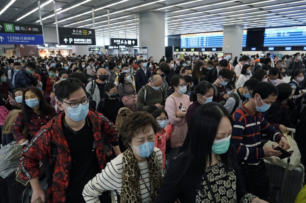 Rattled Markets-Virus In this Thursday, Jan. 23, 2020 file photo, Passengers wear protective face masks at the departure hall of the high speed train station in Hong Kong. (Kin Cheung/AP Photo)