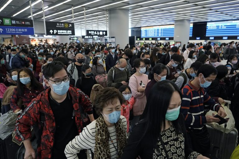In this Thursday, Jan. 23, 2020 file photo, Passengers wear protective face masks at the departure hall of the high speed train station in Hong Kong. (Kin Cheung/AP Photo)
