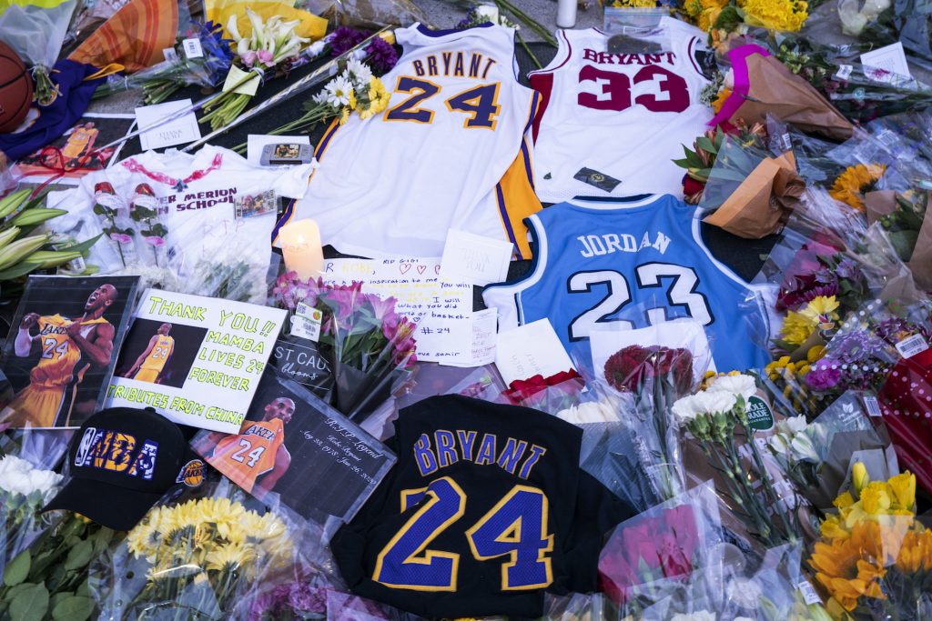 OBIT-BRYANT BASKETBALL Flowers, jerseys and imagery is left in remembrance to Kobe Bryant at a small memorial at the entrance of the Bryant Gymnasium at Lower Merion High School, Monday, Jan. 27, 2020, in Wynnewood, PA. Bryant, the 18-time NBA All-Star who won five championships and became one of the greatest basketball players of his generation during a 20-year career with the Los Angeles Lakers, died in a helicopter crash Sunday, Jan. 26, 2020. (AP Photo/Chris Szagola)