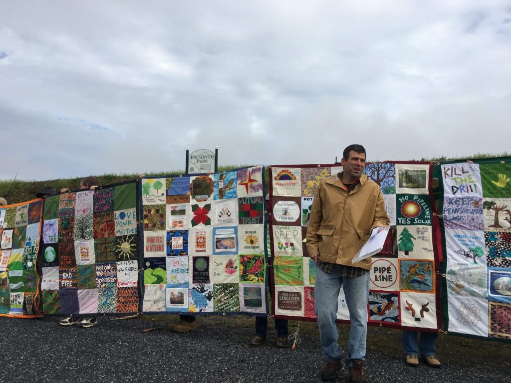 IMG_2195-1920×1440 Mark Clatterbuck stands in front of a quilt designed to protest the Atlantic Sunrise pipeline. (Marie Cusick/StateImpact Pennsylvania)