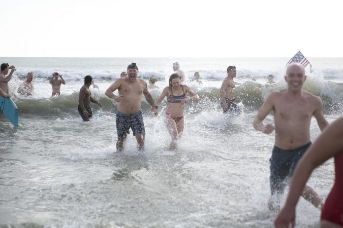 Participants of the the 2020 polar bear plunge in Margate, NJ come out of the water after jumping in on Wednesday, January 1, 2020. (Miguel Martinez for WHYY)