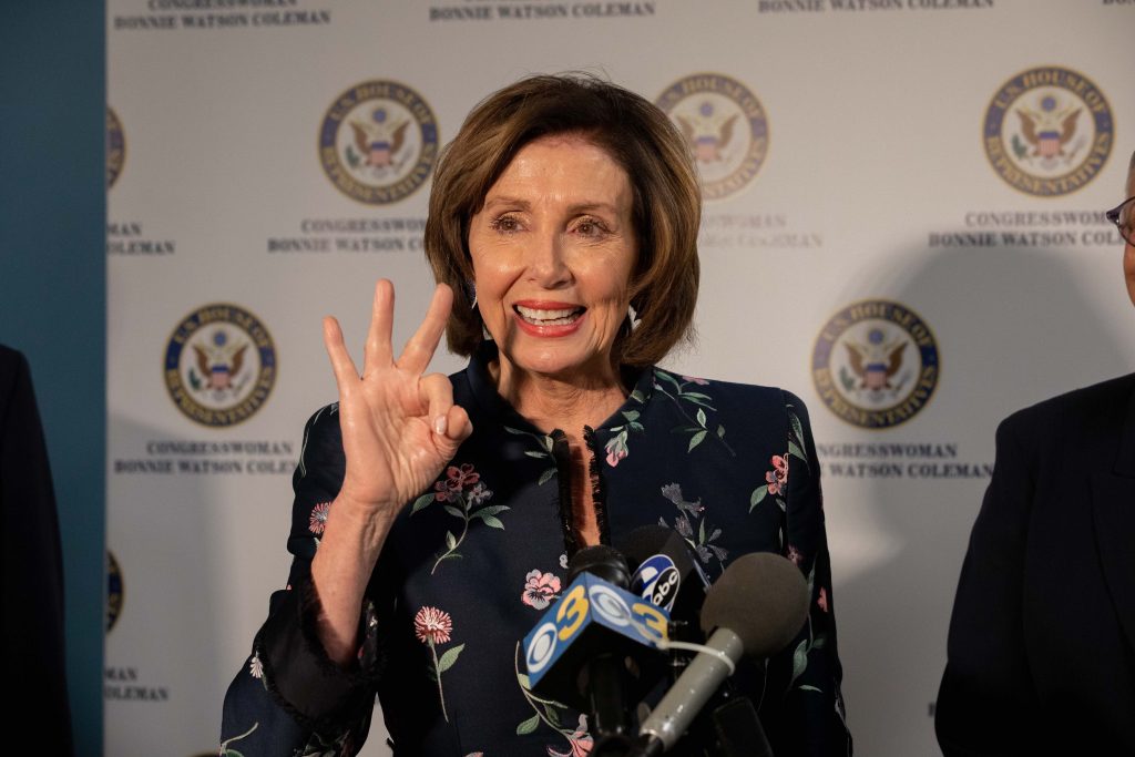 2020 02 08-b haydu-nancy pelosi bonnie watson coleman-trenton new jersey henry j austin health center-healthcare prescription drug prices press conference -26 Speaker Nancy Pelosi holds up three fingers in reference to H.R. 3, the Elijah E. Cummings Lower Drug Costs Now Act in Trenton, NJ. (Becca Haydu for WHYY)