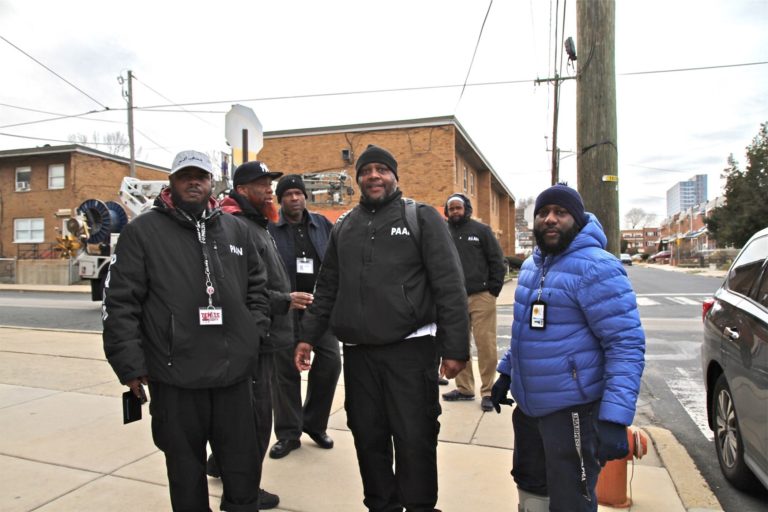Twenty PAAN members canvassed the neighborhood offering city resources after a quadruple shooting rocked the community Wednesday. (Ximena Conde/WHYY)