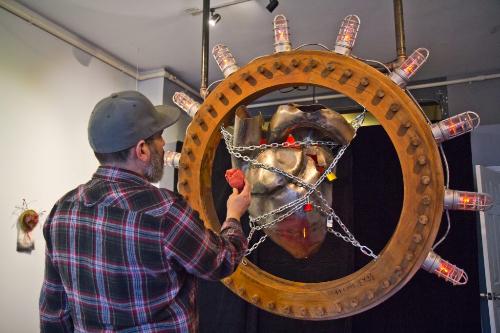 2020 2 13 k paynter trashed heart-18 Terry McCall, one of the owners of Scavengers United, compares his heart sculpture to an anatomical foam model. (Kimberly Paynter/WHYY)