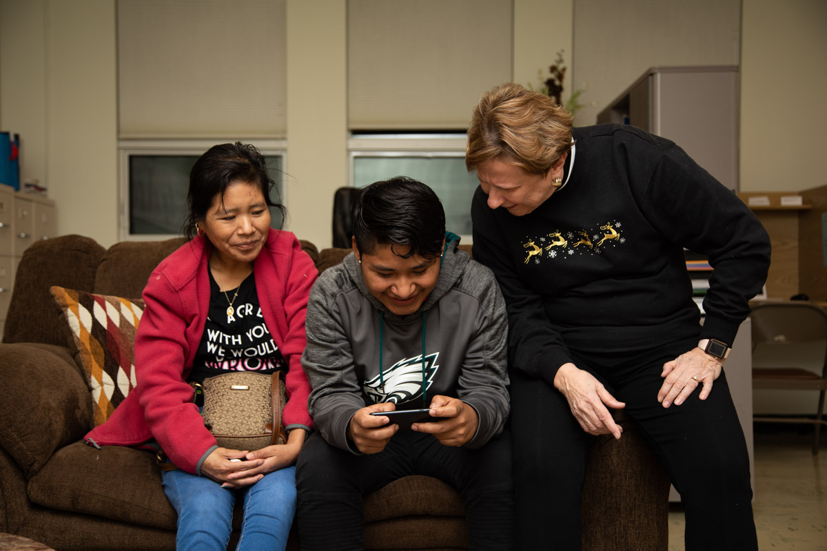 Fredy and Margarita with Sue Marshall at the King Street Ministry Center in Chambersburg, Pa. (Jeffrey Stockbridge for Keystone Crossroads)
