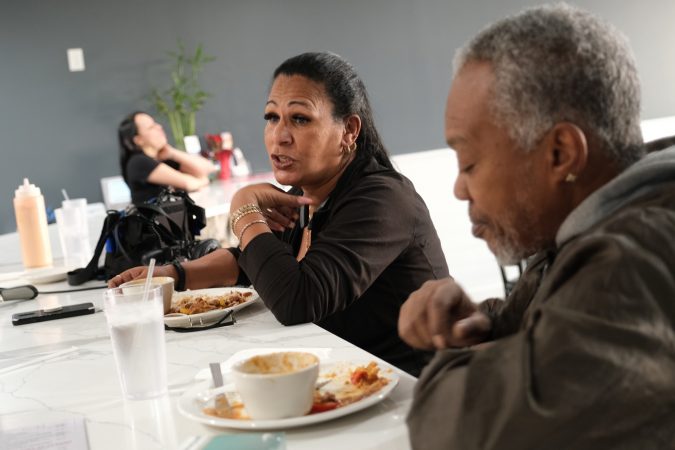 Iris Batista, left, of Mount Penn, talks while seated next to James Porter, right, at Mi Casa Su Casa in Reading, Pennsylvania. (Matt Smith for Keystone Crossroads)