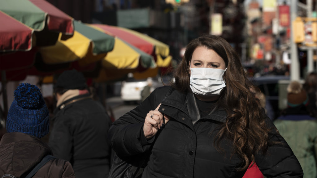 A woman, who declined to give her name, wears a mask in New York out of concern for the newly emerged coronavirus. A woman, who declined to give her name, wears a mask in New York out of concern for the coronavirus. Experts say the masks do not necessarily help prevent the spread of the virus. (Mark Lennihan/AP Photo)