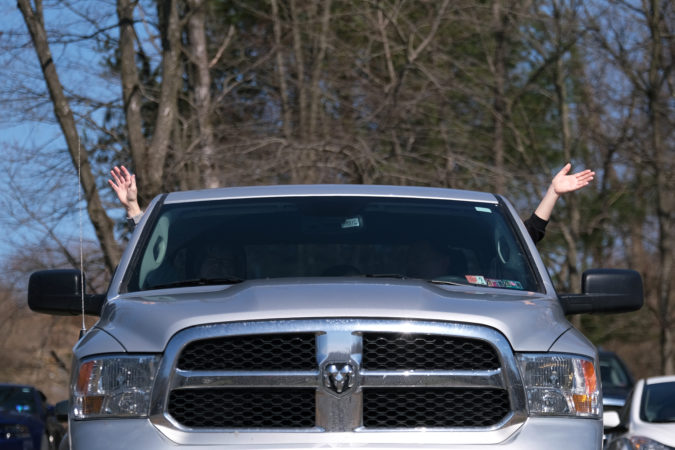 Parishioners raise their hands as they sit in their cars during the worship service at Becky's Drive-In. (Matt Smith for Keystone Crossroads)
