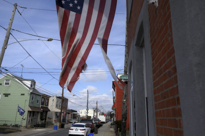 A torn American flag waves on a residential street in Bridesburg. (Bastiaan Slabbers for Keystone Crossroads)