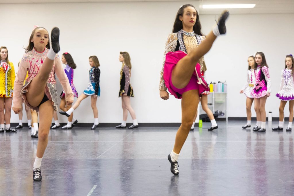 2020 03 11-ecohen-mcdade cara irish dance school-newtown square-5 Dancers from the McDade-Cara School of Irish Dance warm up in their competition dresses for a dress rehearsal for the 2020 St. Patrick's Day Parade. (Emily Cohen for WHYY)
