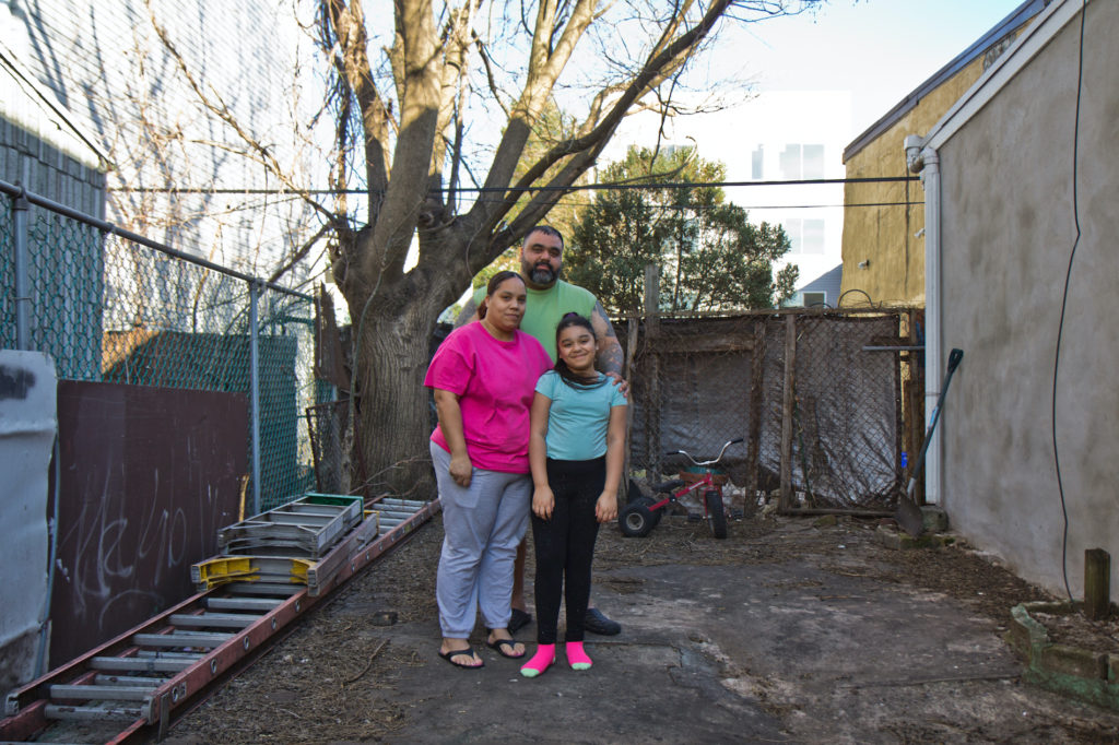 2020 3 10 k paynter landbank garden kensington-11 Adamarie Baez and Daniel Ortiz with their 10-year-old daughter Kaylee in the lot next to their home they’ve maintained and gardened in for years. (Kimberly Paynter/WHYY)