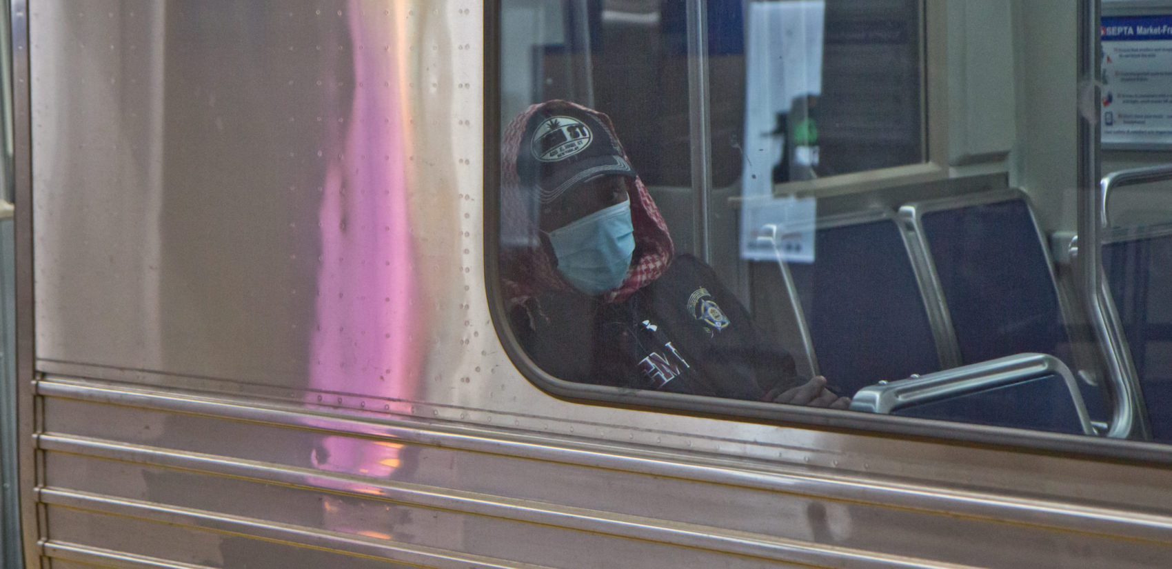 A subway rider in Philadelphia dons a surgical mask. (Kimberly Paynter/WHYY)