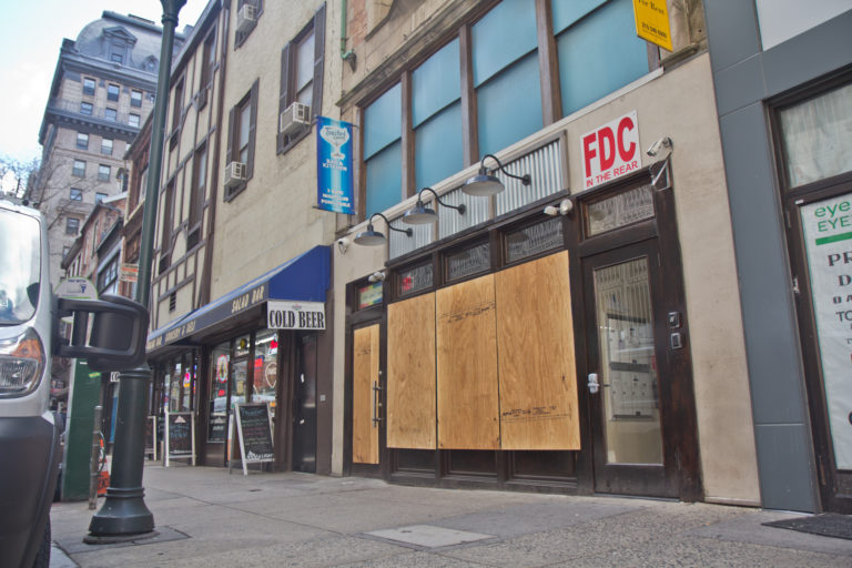 Businesses on Walnut Street in Center City Philadelphia are boarded up during non-essential business shutdown orders aimed to slow the spread of COVID-19. (Kimberly Paynter/WHYY)