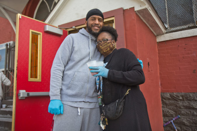 Javon Kinnard (left) and Serena Poindexter, members of the New Kingdom Baptist Church in Kensginton, have been volunteering to hand out meals to people in need. (Kimberly Paynter/WHYY)