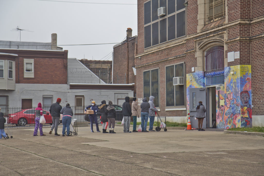2020 3 30 k paynter free food pickup-9 Hungry residents wait in line to pick up free food from the city Monday at Aspira Charter Stetson in Philadelphia. (Kimberly Paynter/WHYY)